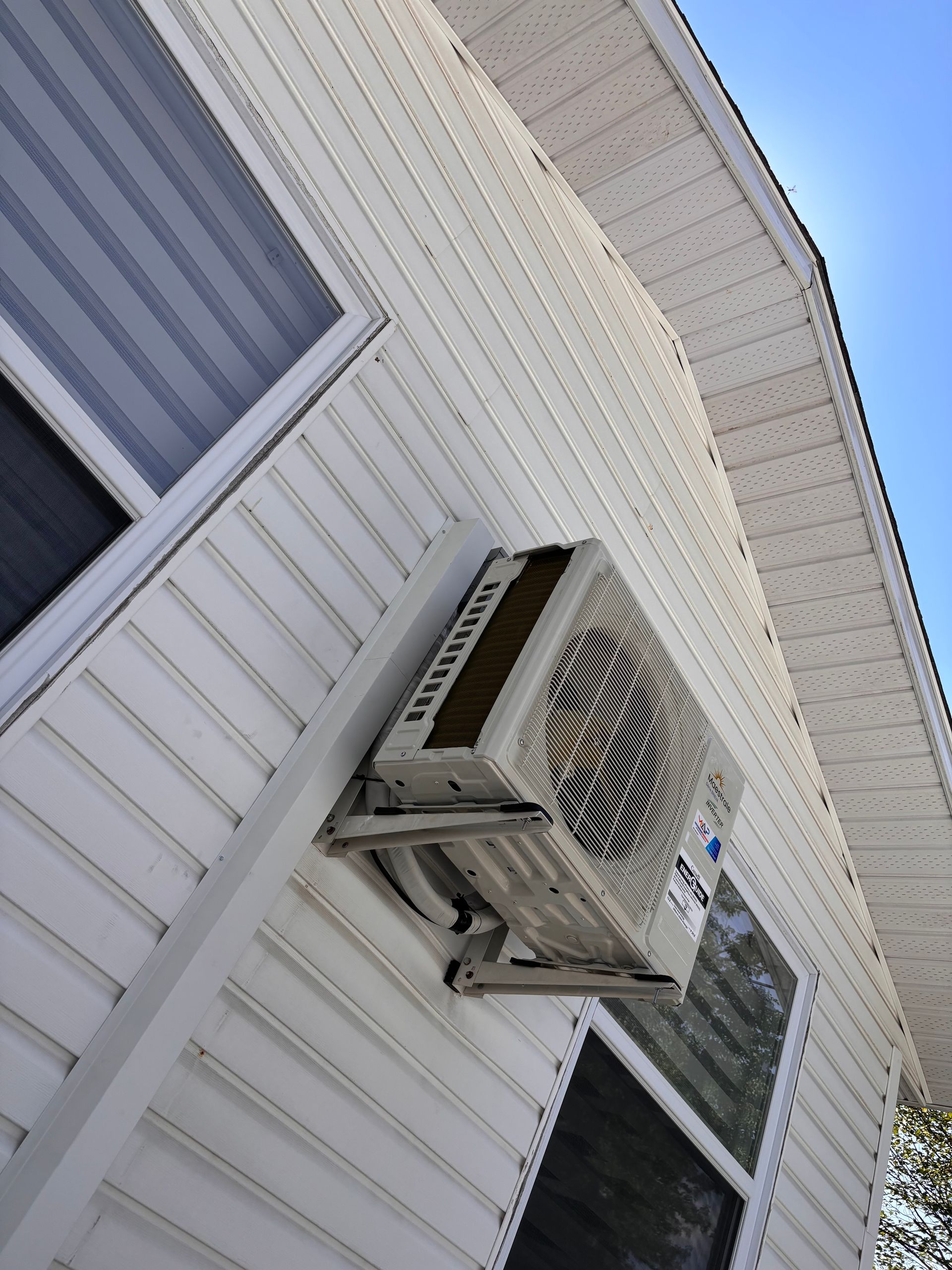 Un climatiseur est monté sur le côté d'une maison