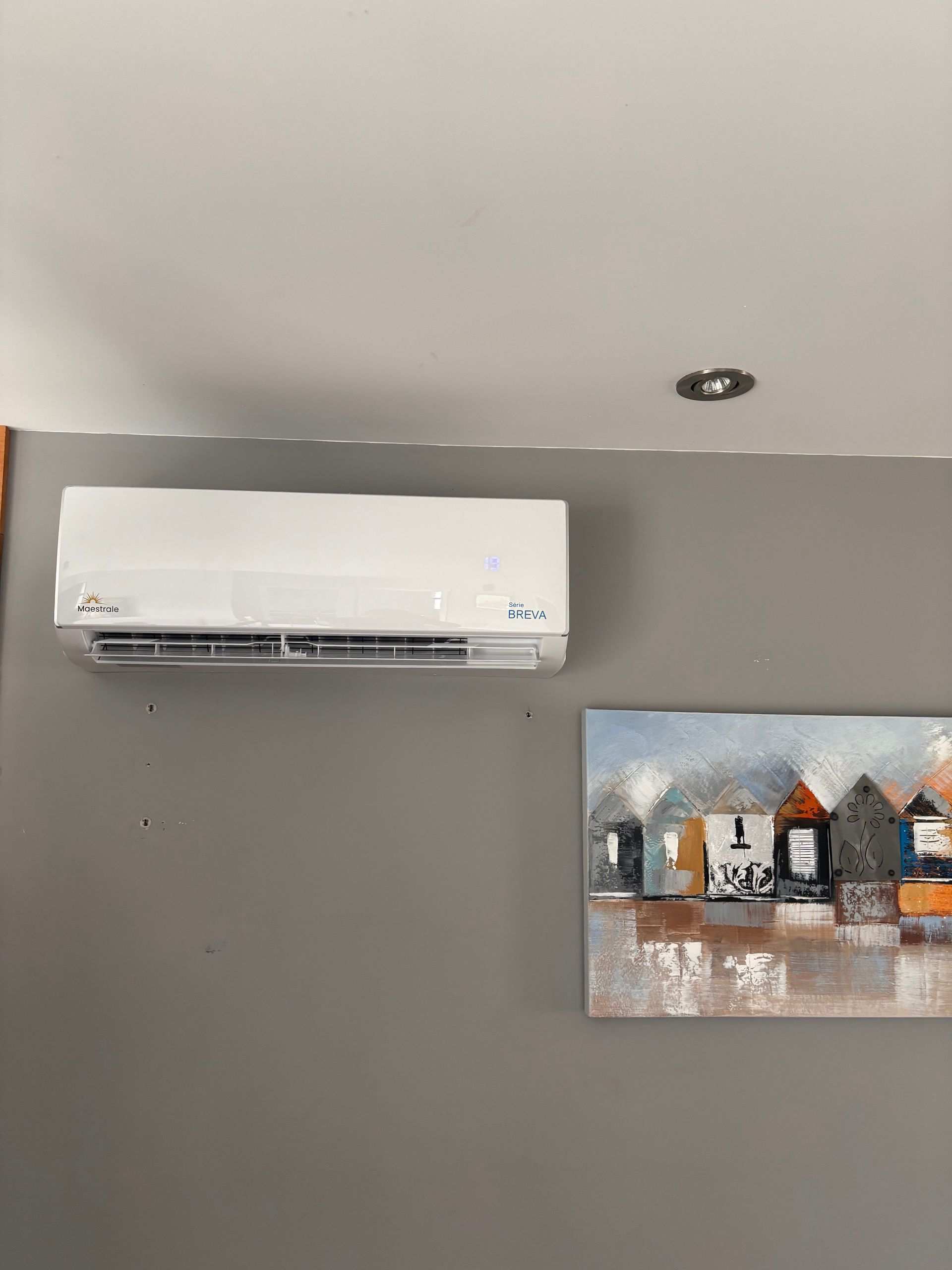 Une pièce avec deux climatiseurs et un tableau au mur.