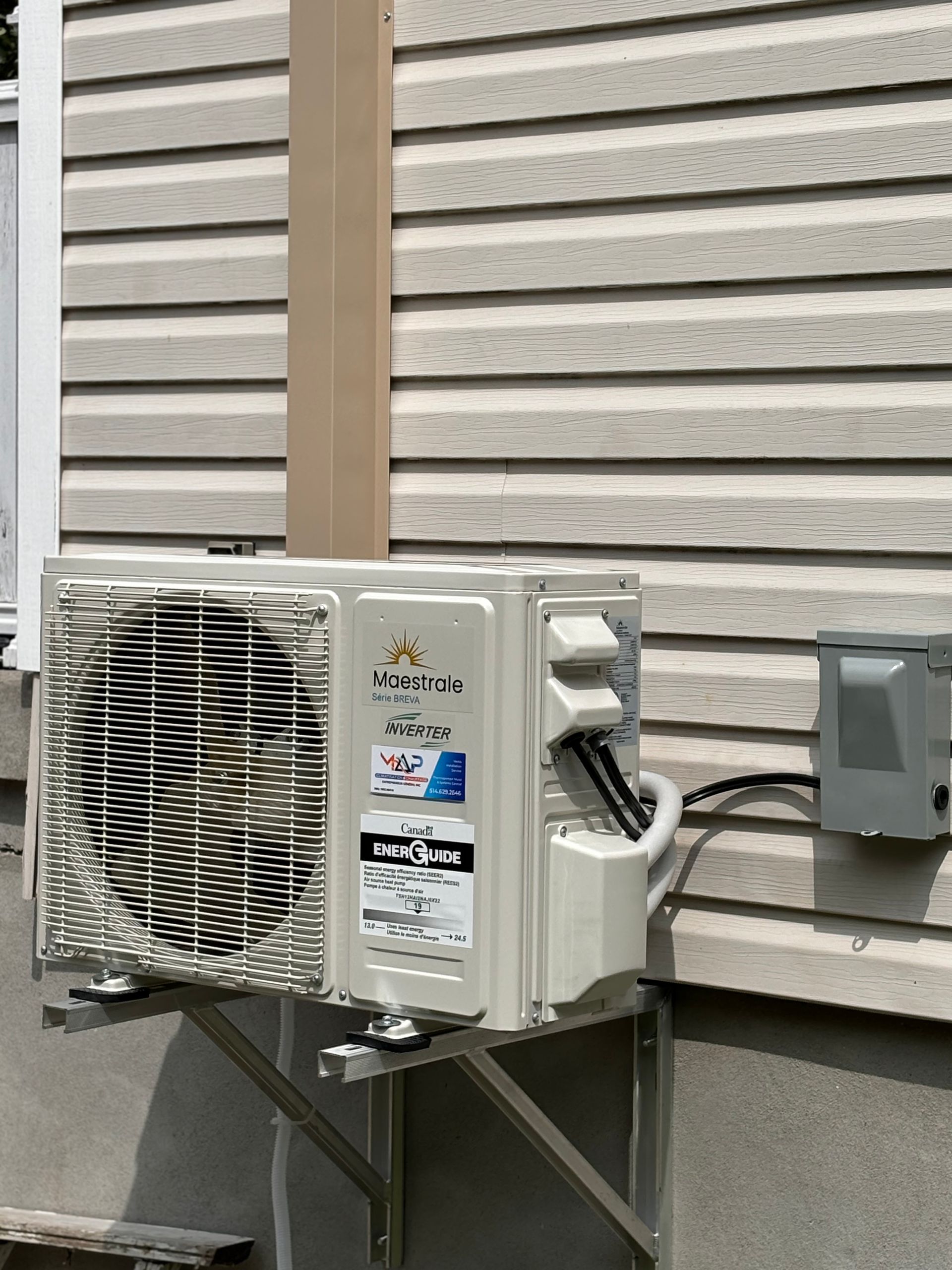 Un climatiseur blanc est monté sur le côté d'une maison.