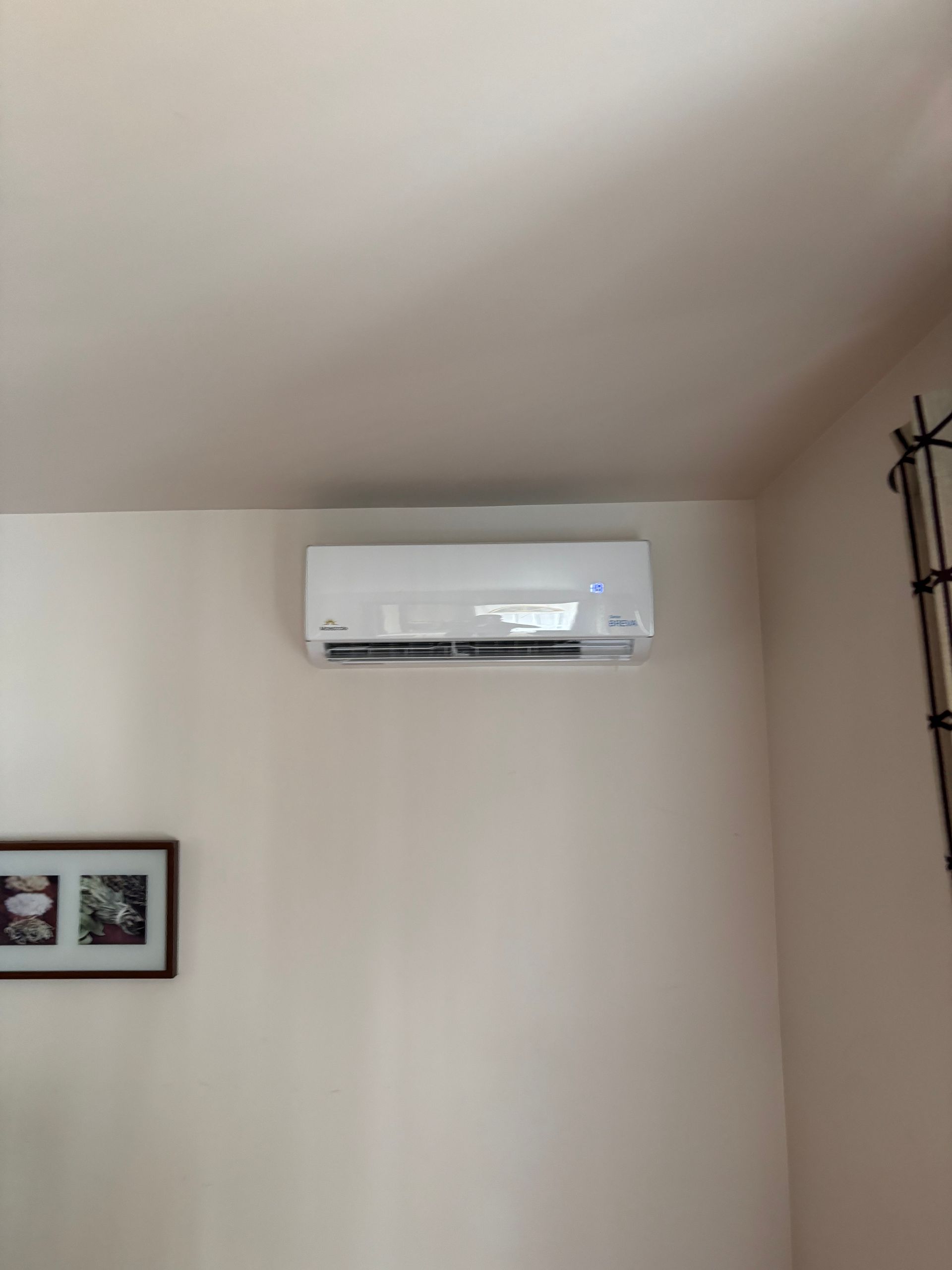 Un climatiseur blanc est suspendu au plafond d'une pièce.