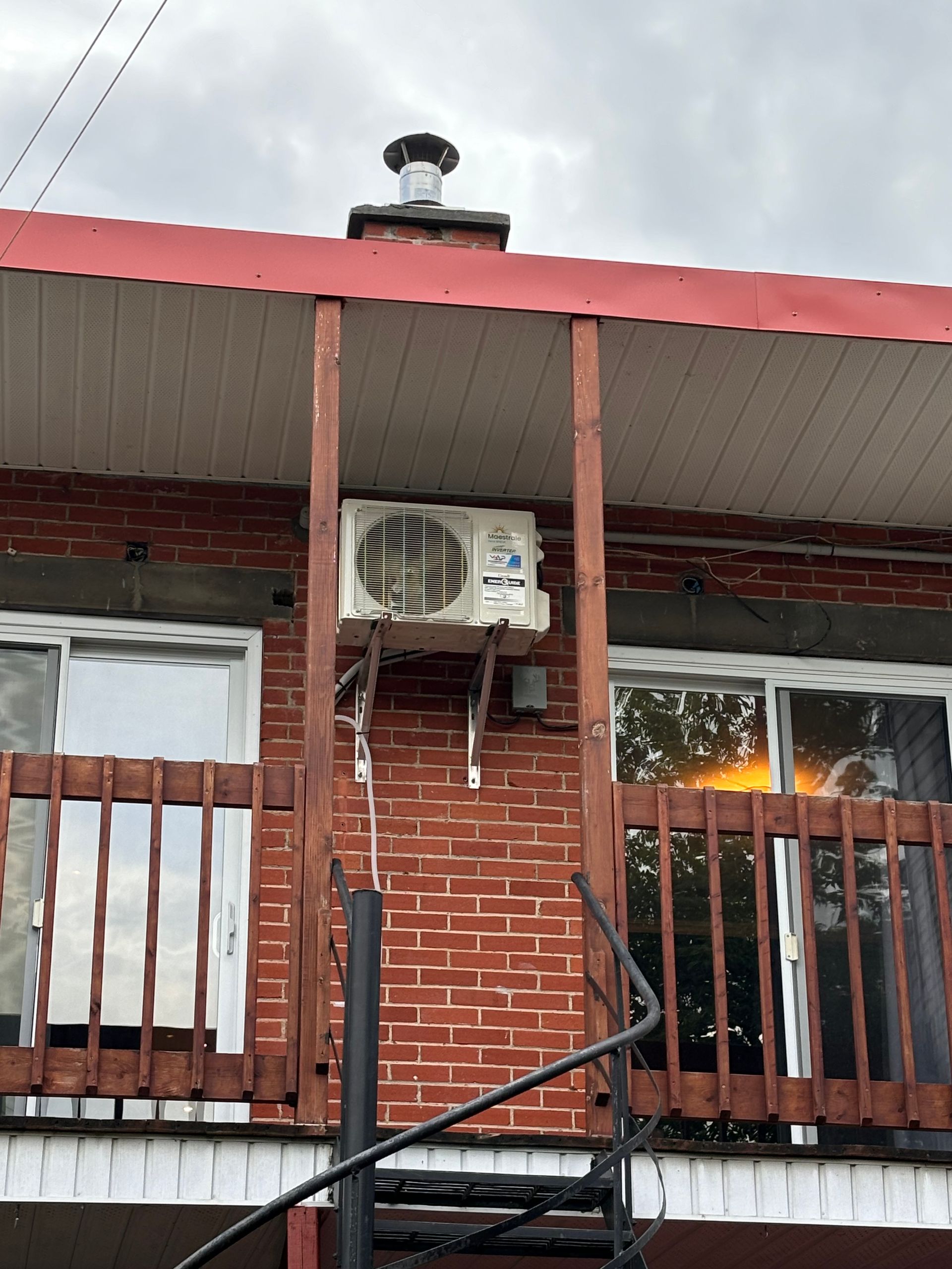 Un bâtiment en briques avec un balcon et un climatiseur sur le côté