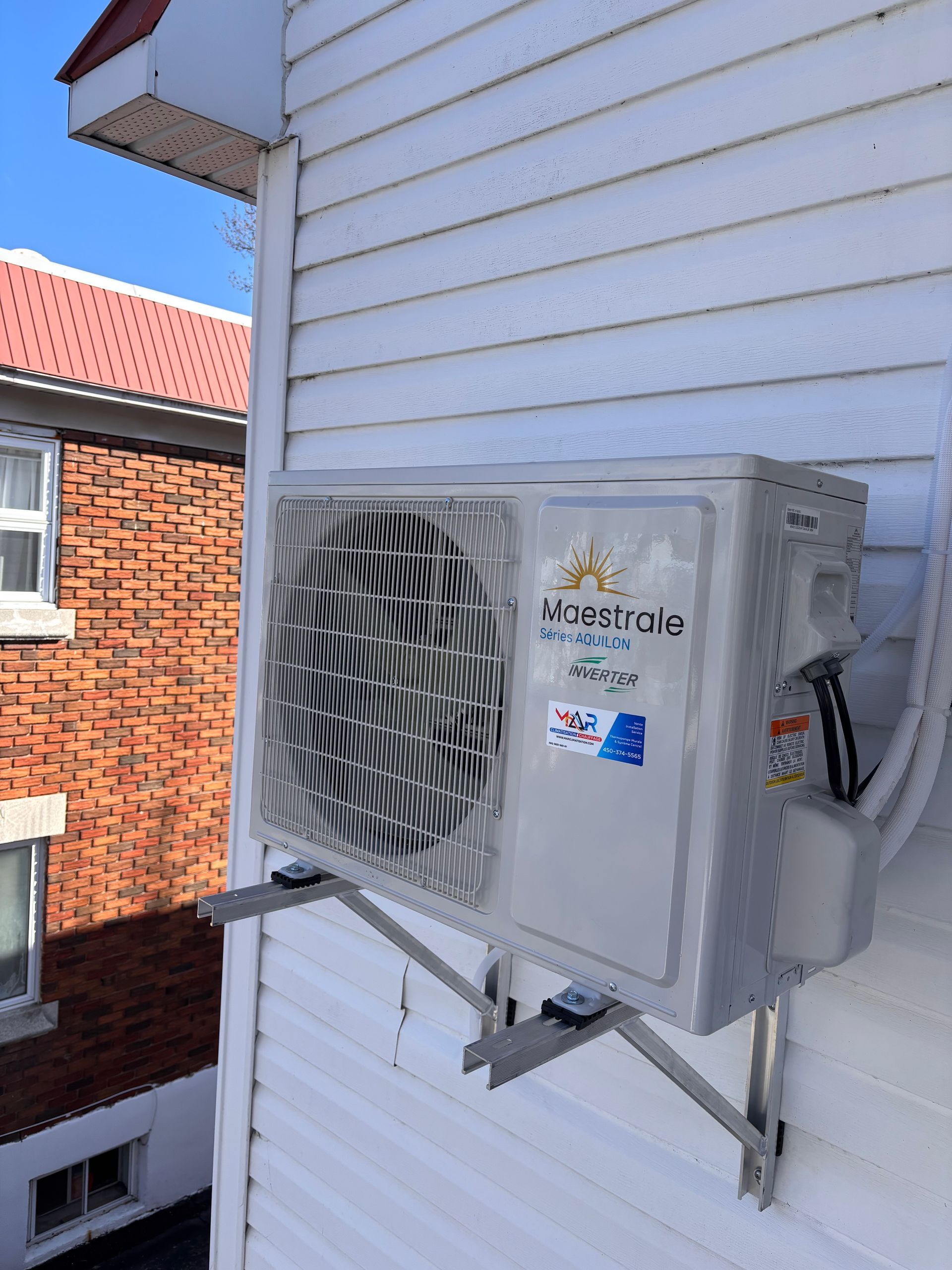 Un climatiseur est monté sur le côté d'une maison.