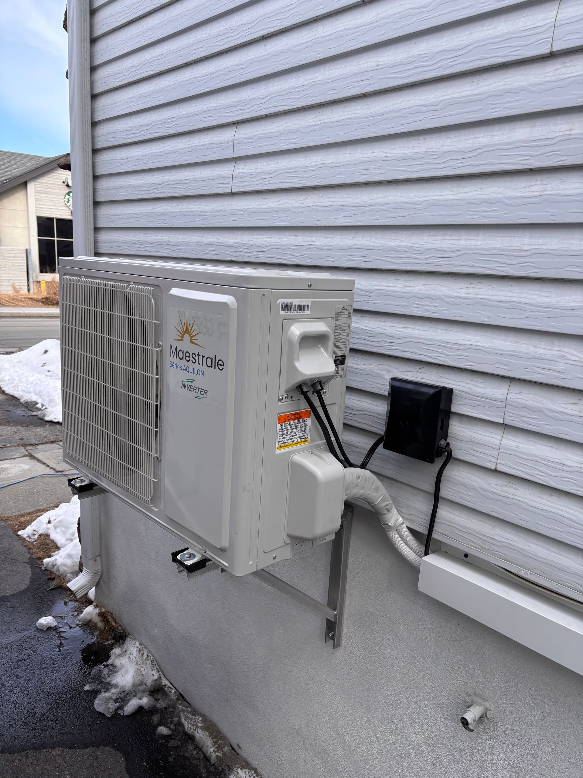 Un climatiseur est installé sur le côté d'une maison.