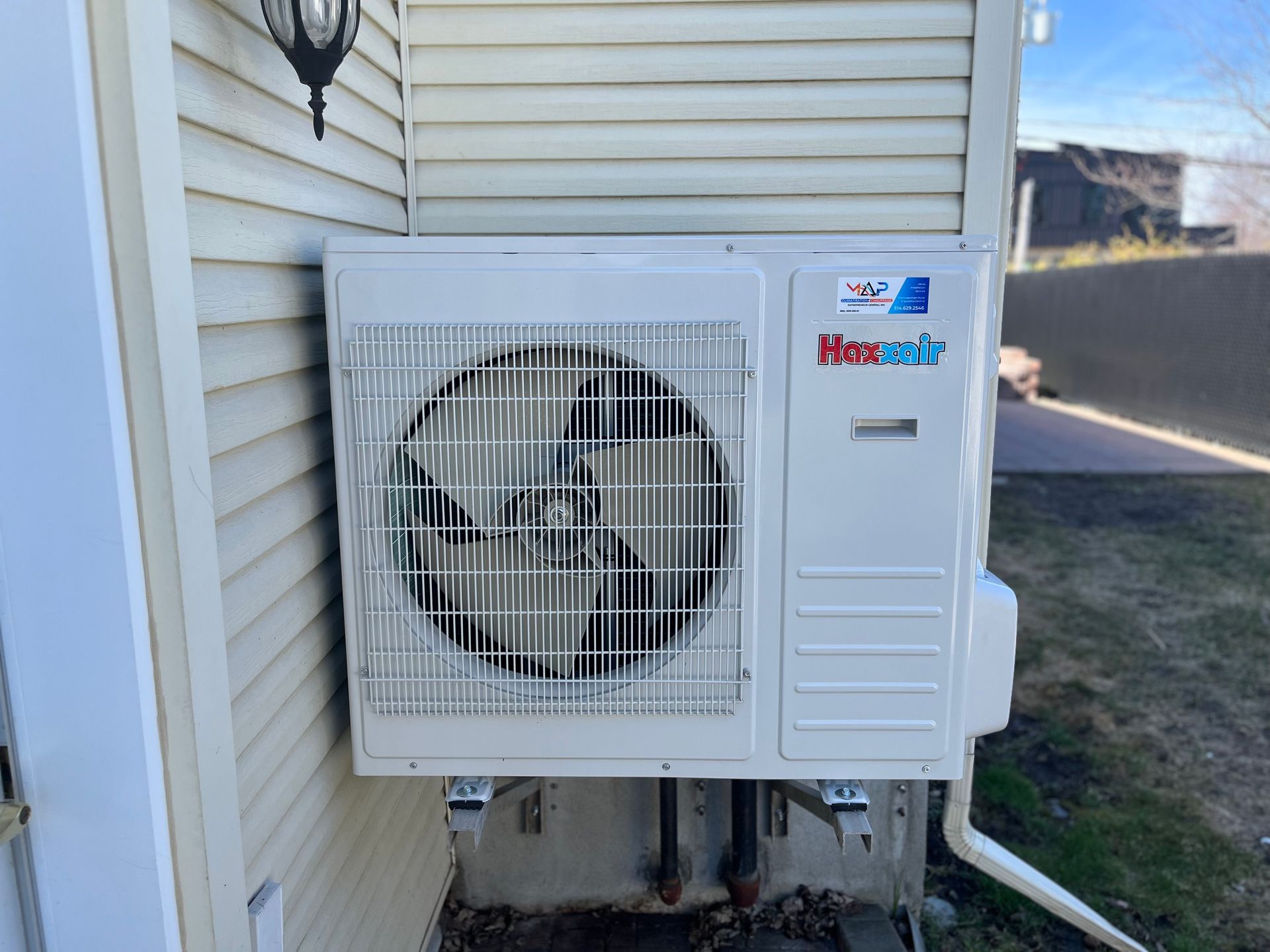 Un climatiseur blanc est monté sur le côté d'une maison.