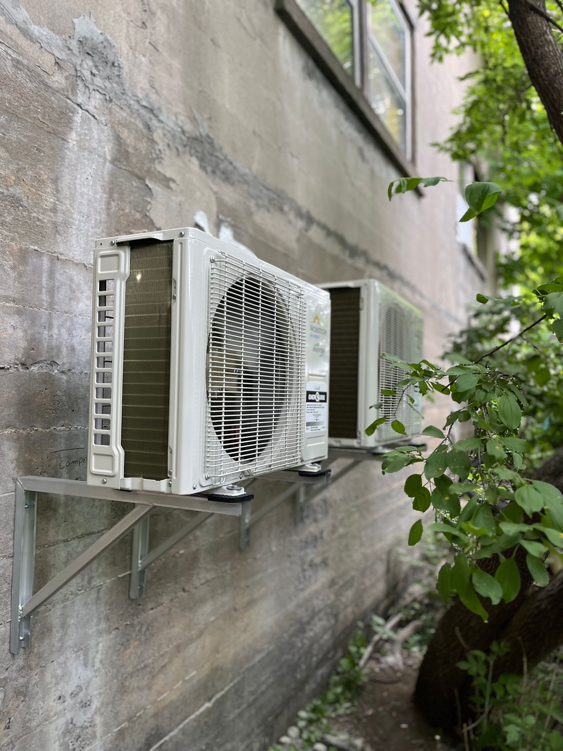 Deux climatiseurs sont montés sur le côté d'un bâtiment.