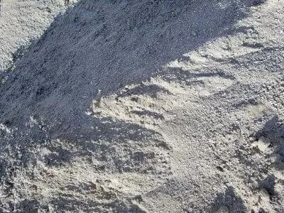 Gray pile of aggregate material with shadows.