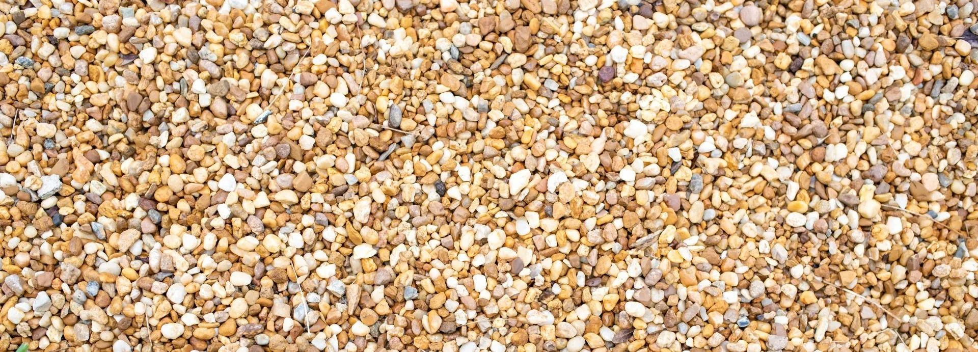 Close-up of a surface covered with small, light-brown pebbles.