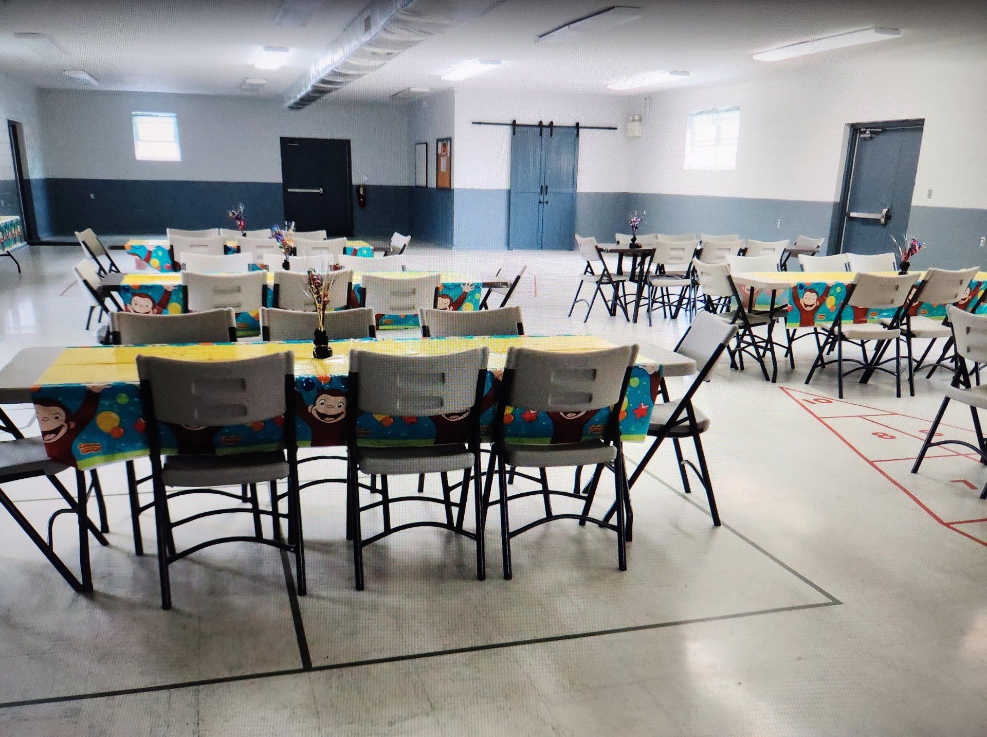 A large room with tables and chairs set up for a party