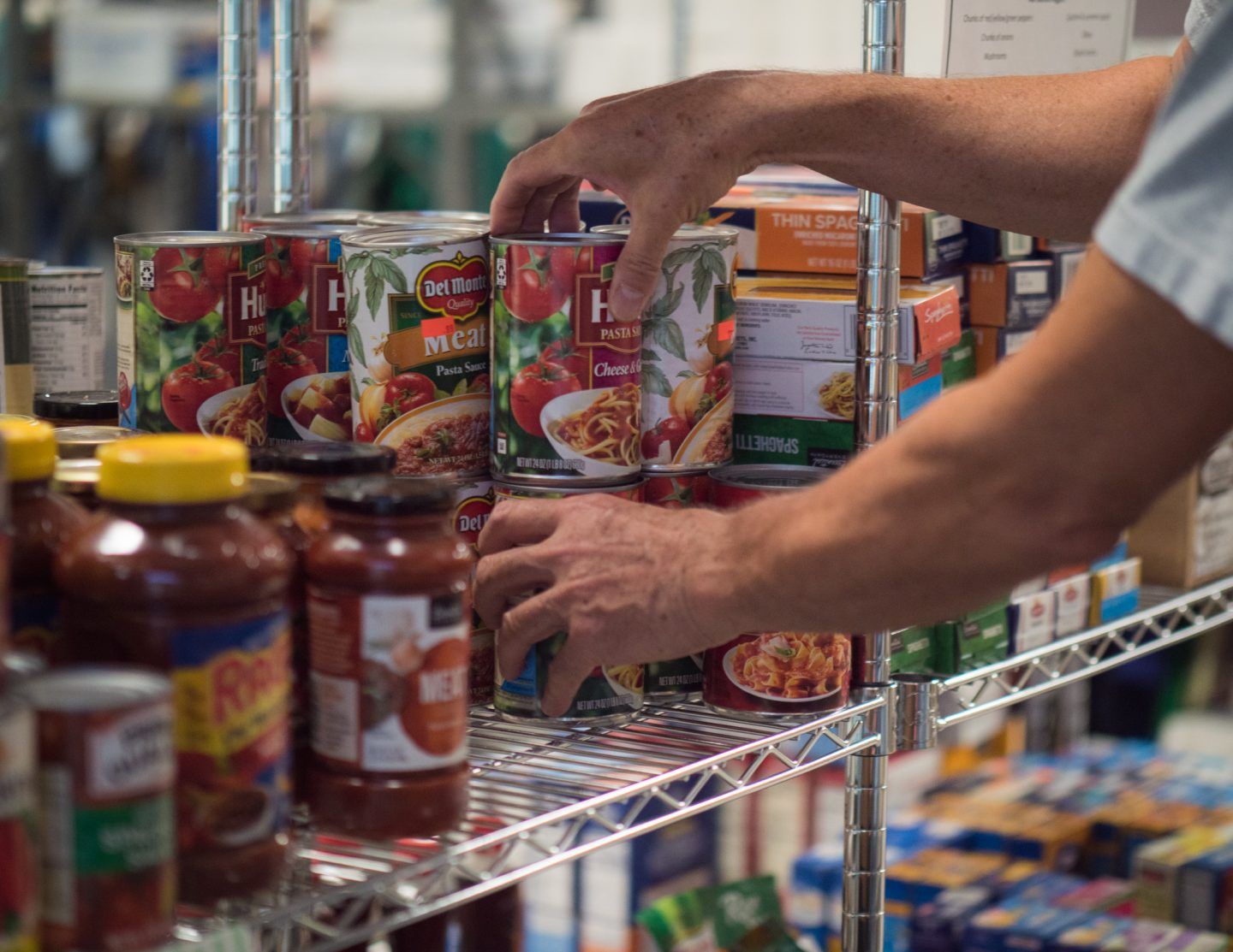 A man reaches for a can of heinz tomato sauce