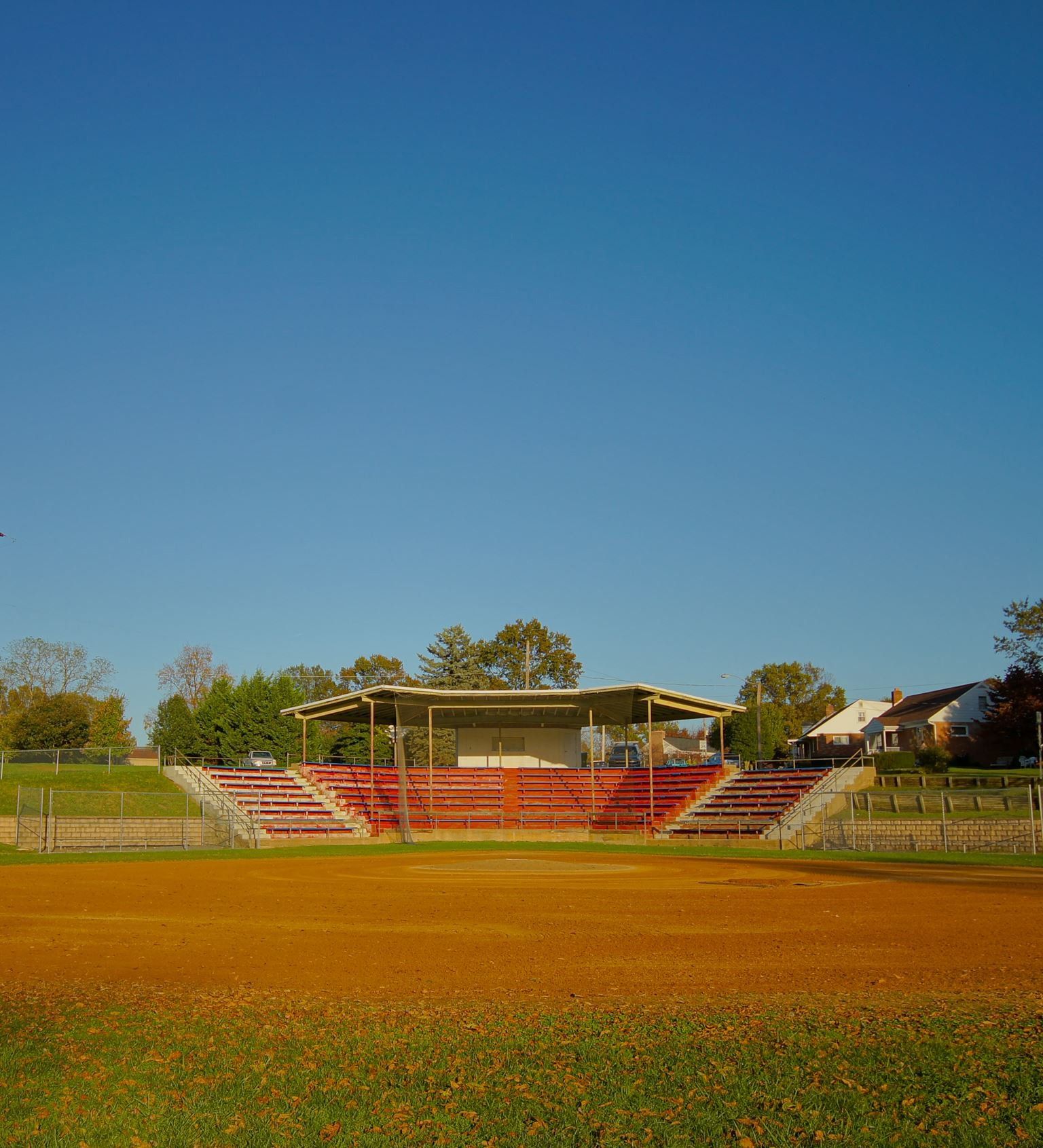 A baseball field with a stadium in the background