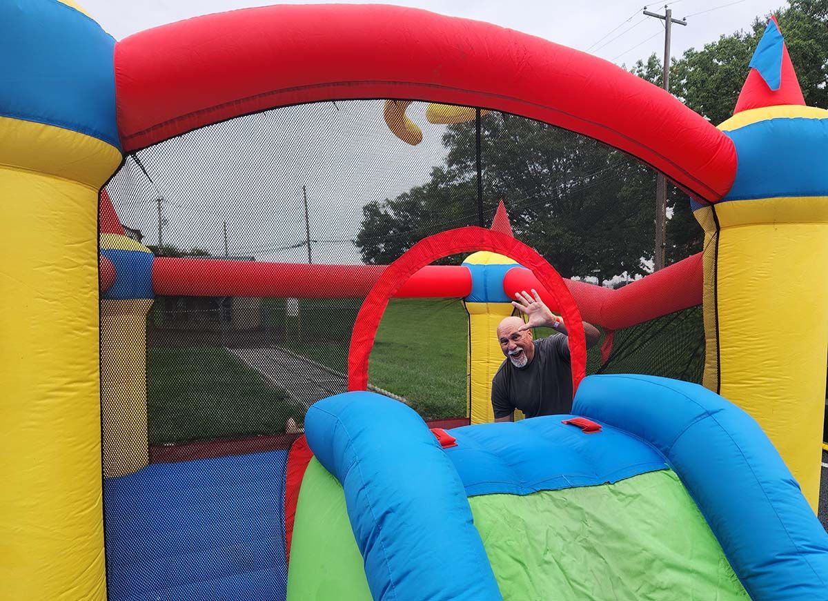 A man is playing in an inflatable bouncy house