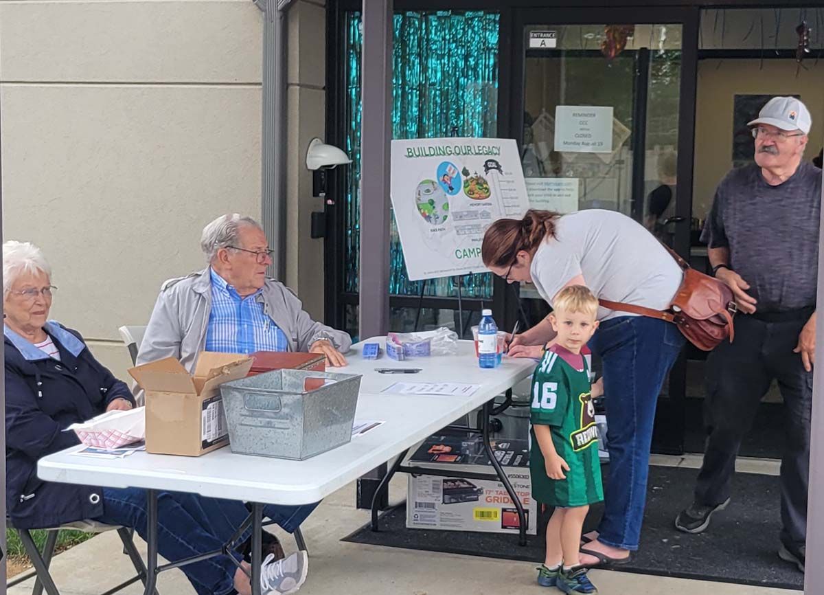 A group of people are gathered around a table with the number 16 on it