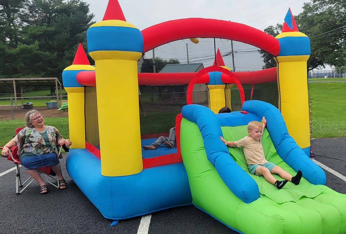 Two children are playing in an inflatable castle with a slide