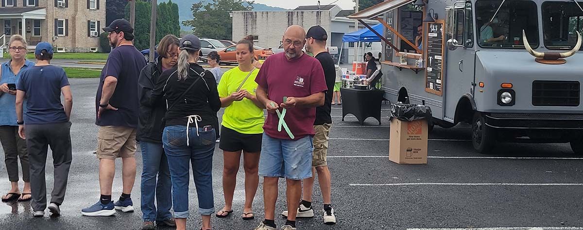 A group of people standing in front of a food truck