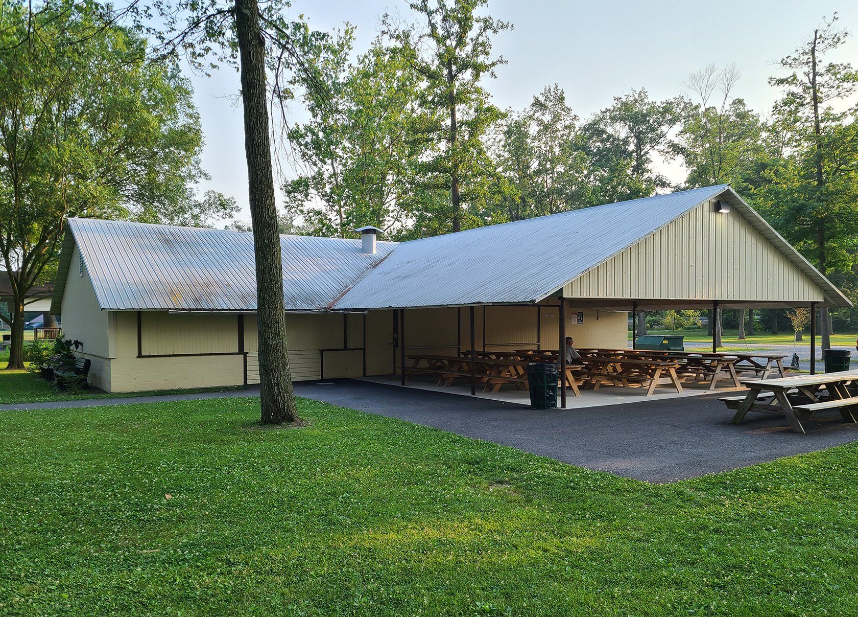 A picnic shelter with tables and chairs in a park