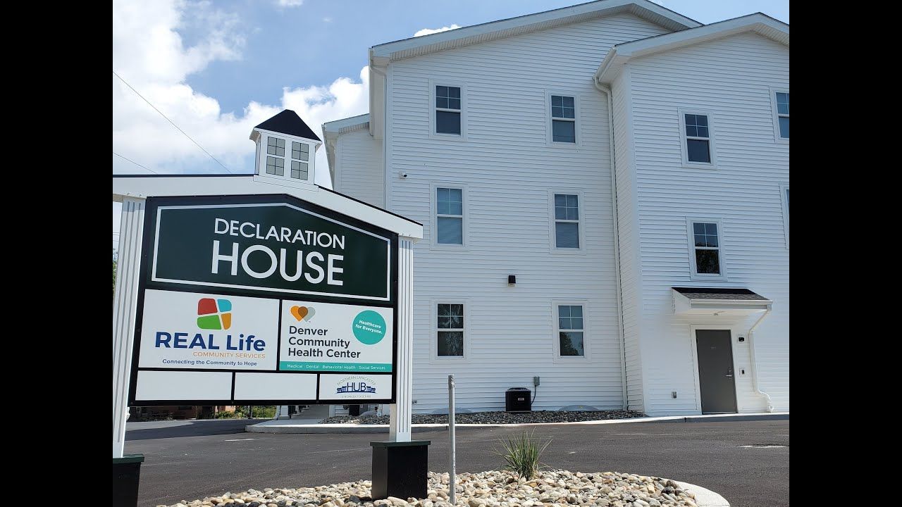 A white building with a sign that says house