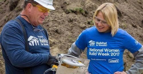 A man and a woman are standing next to each other on a construction site.