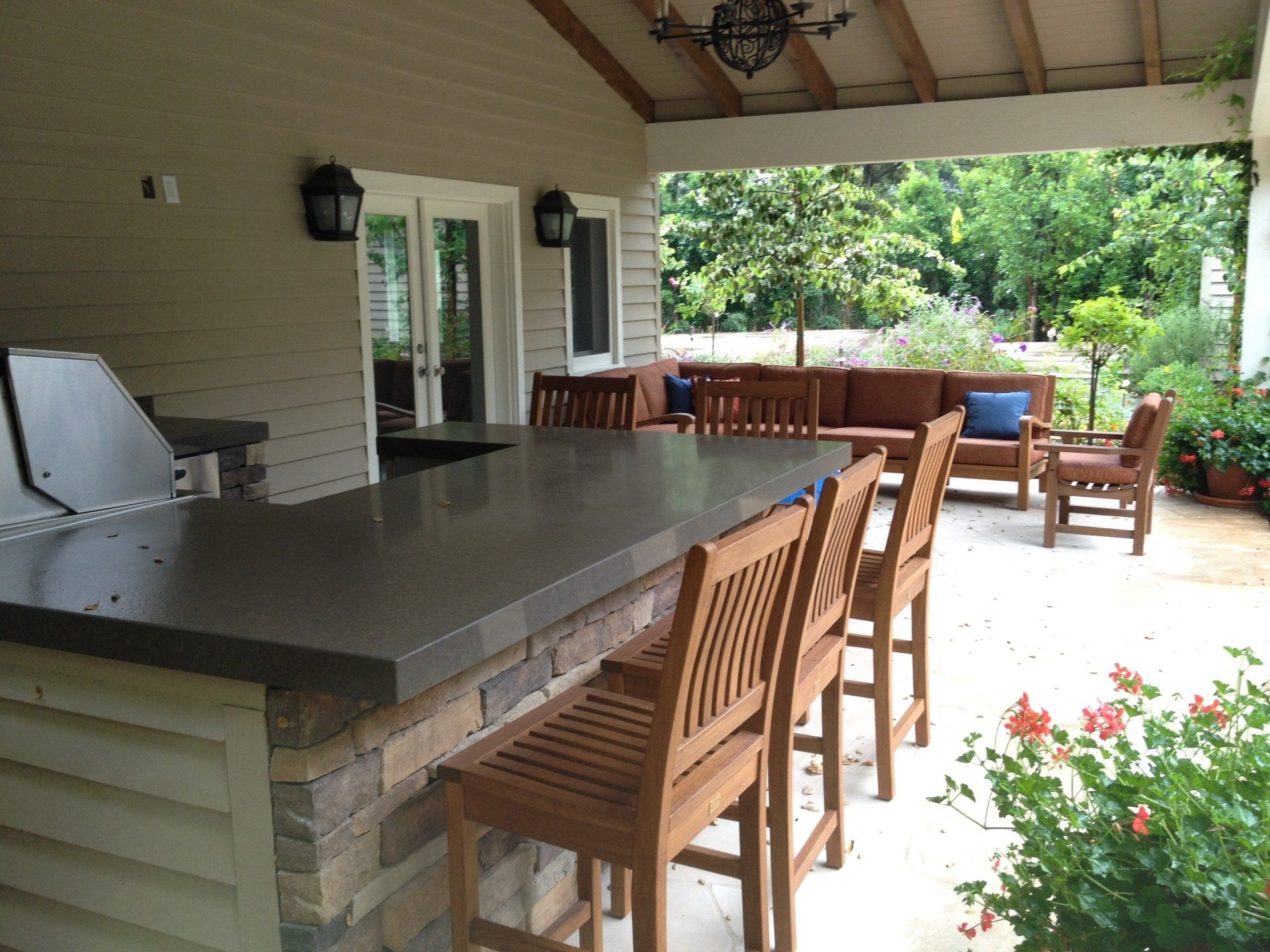 A covered patio with a bar and chairs