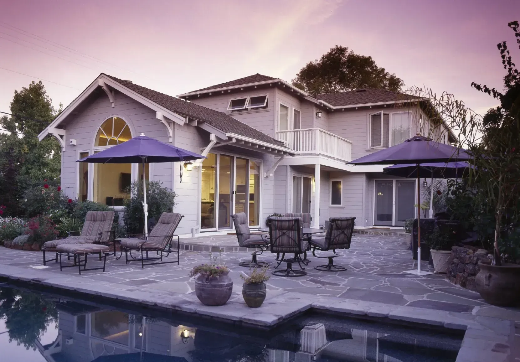 A large house with a swimming pool and patio furniture