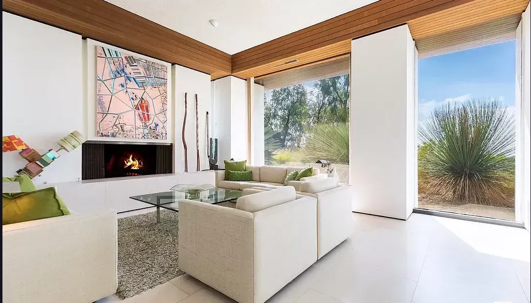 A living room with white furniture and a fireplace