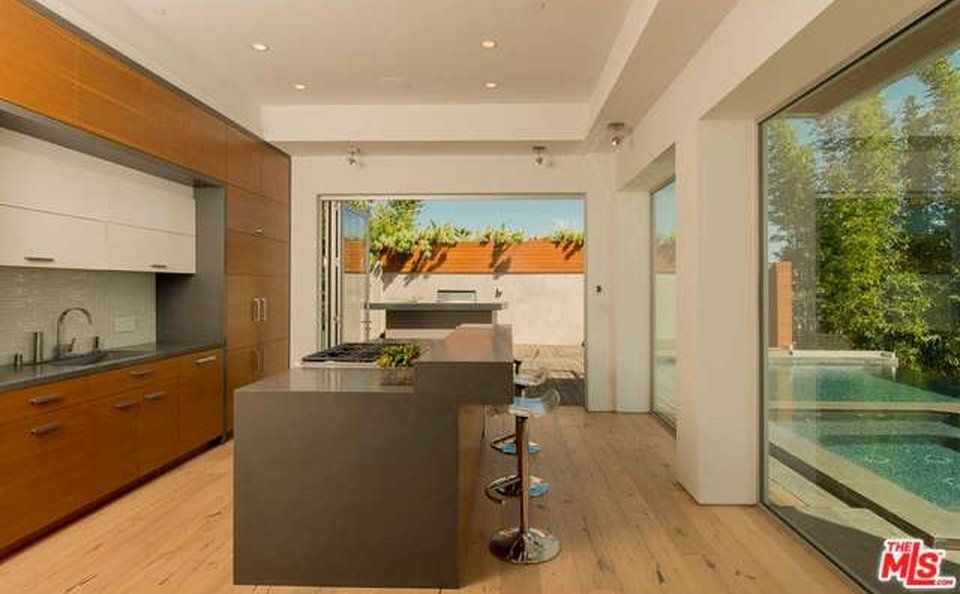 A kitchen with a large island and a large window