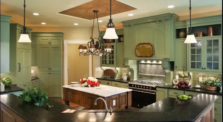 A kitchen with green cabinets and black counter tops