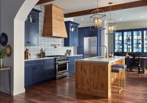 A kitchen with blue cabinets and a wooden island.