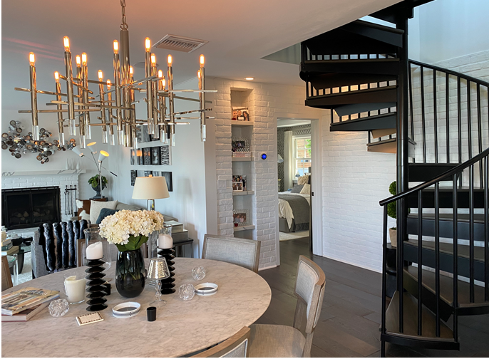 A dining room with a table and chairs and a spiral staircase