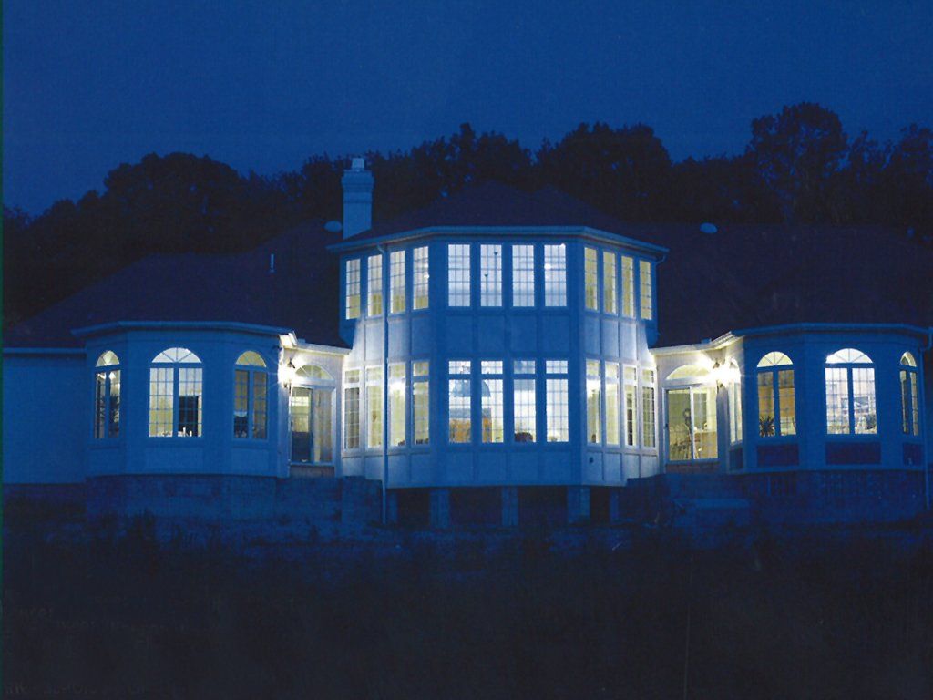 A large white house is lit up at night