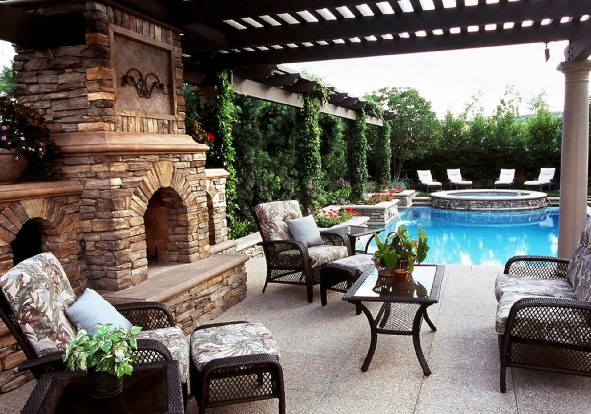A patio with a fireplace and a swimming pool