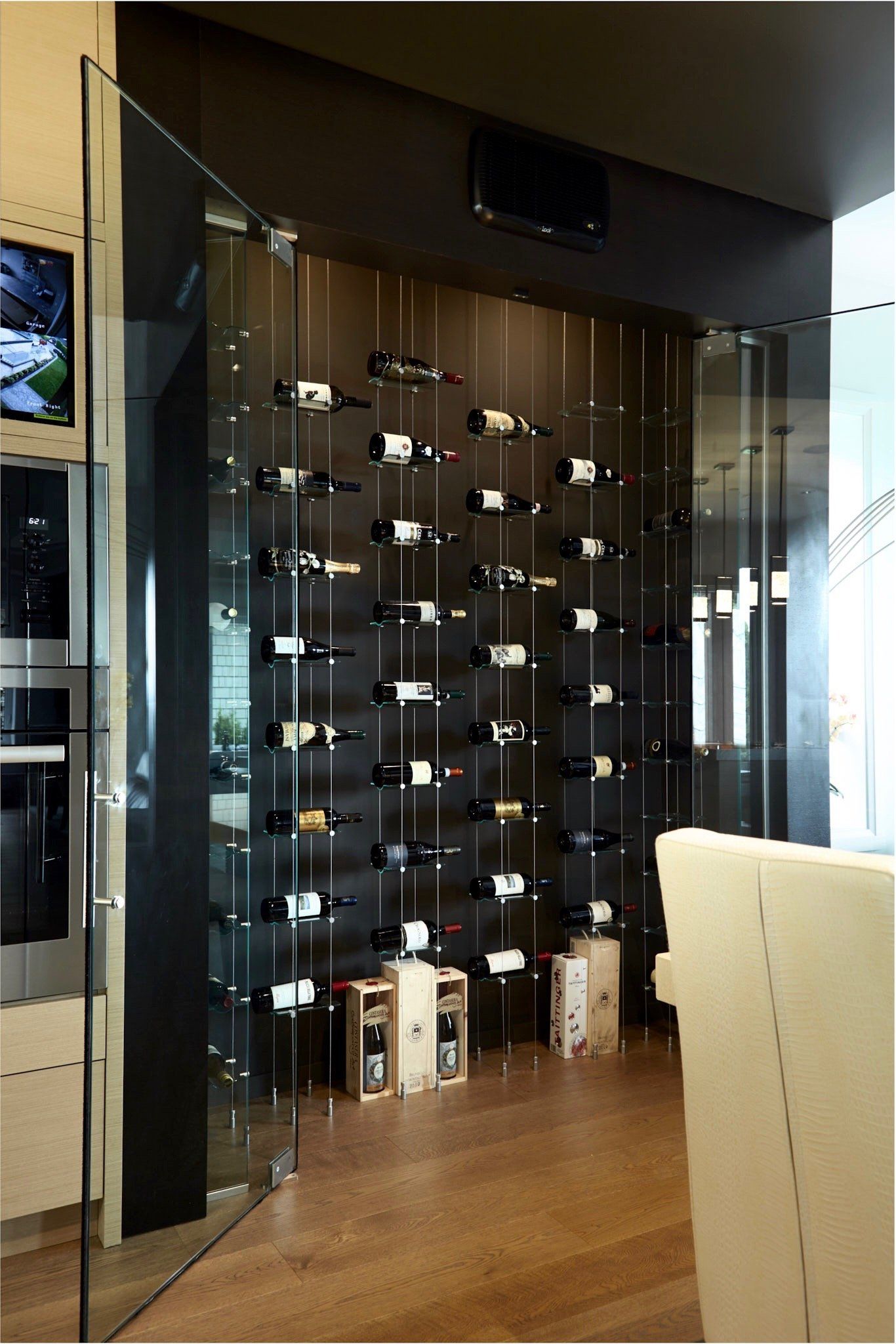 A wall of wine bottles behind a glass door