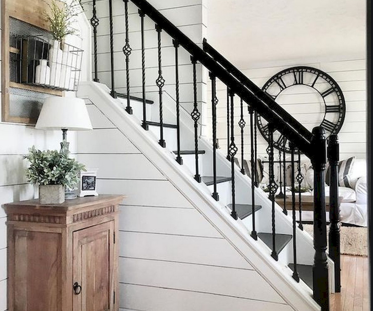 There is a clock on the wall next to the stairs.