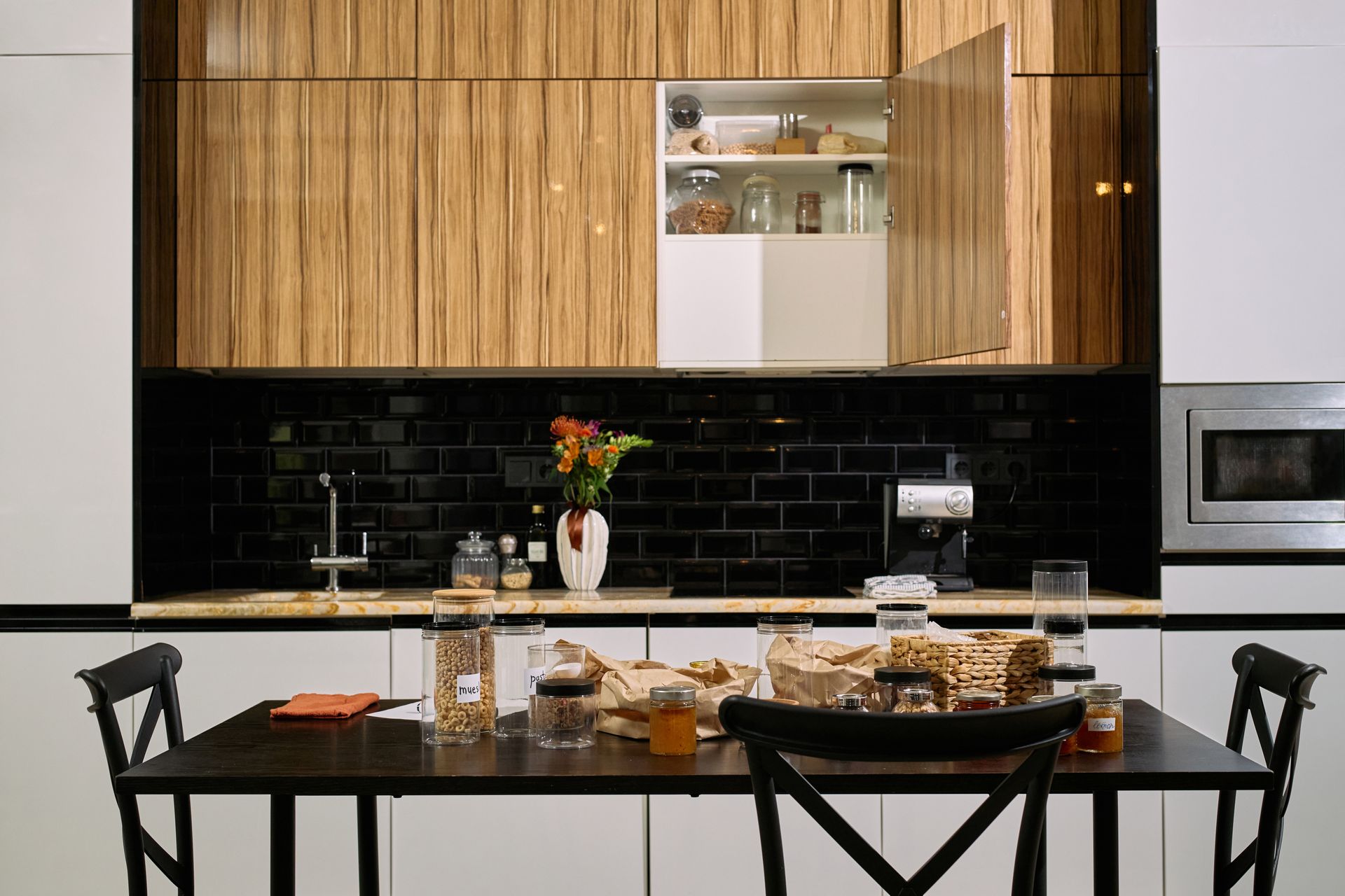 A kitchen with black cabinets and stainless steel appliances
