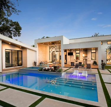 A house with a large swimming pool in front of it