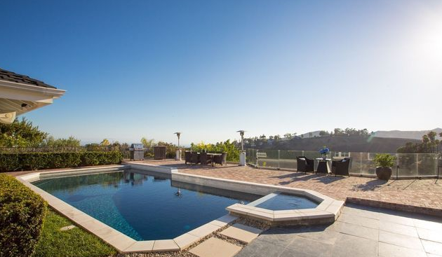 A large swimming pool in the backyard of a house