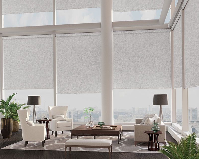 A living room with a lot of windows and white furniture