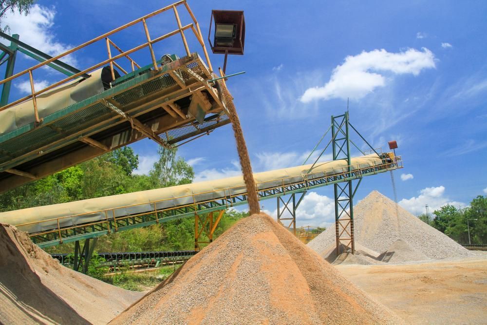 A Conveyor Belt is Pouring Sand Into a Pile of Sand — Nicks Readymix in Cooroy, QLD