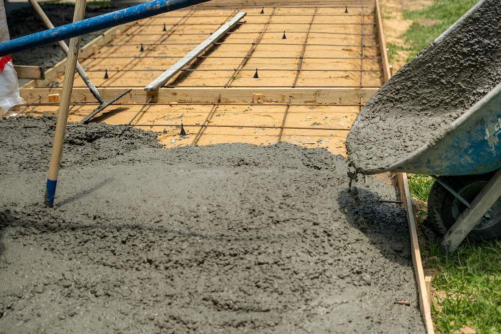 A Wheelbarrow is Pouring Concrete Into a Concrete Slab — Nicks Readymix in Cooroy, QLD