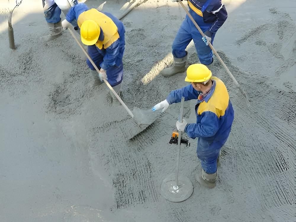 A Group of Construction Workers Are Working on a Concrete Floor — Nicks Readymix in Imbil, QLD