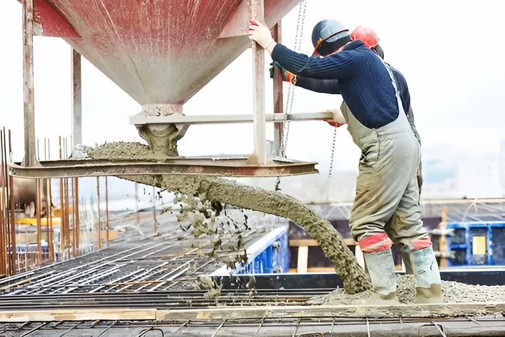 A Man is Pouring Concrete From a Silo on a Construction Site — Nicks Readymix in Poona, QLD
