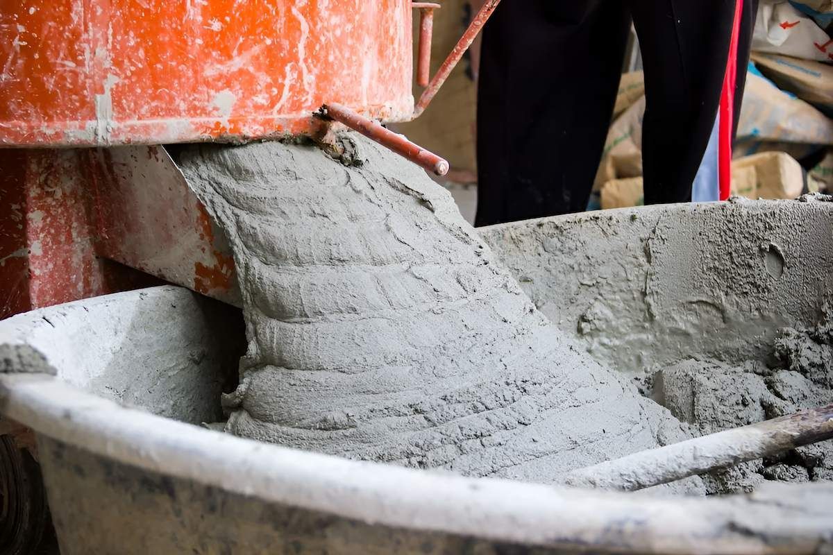 A Person is Pouring Concrete Into a Bucket — Nicks Readymix in Cooroy, QLD
