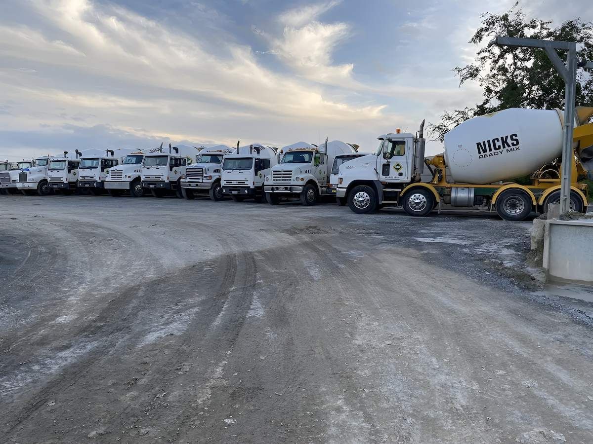 A Row of Trucks Are Parked on the Side of a Dirt Road — Nicks Readymix in Monkland, QLD