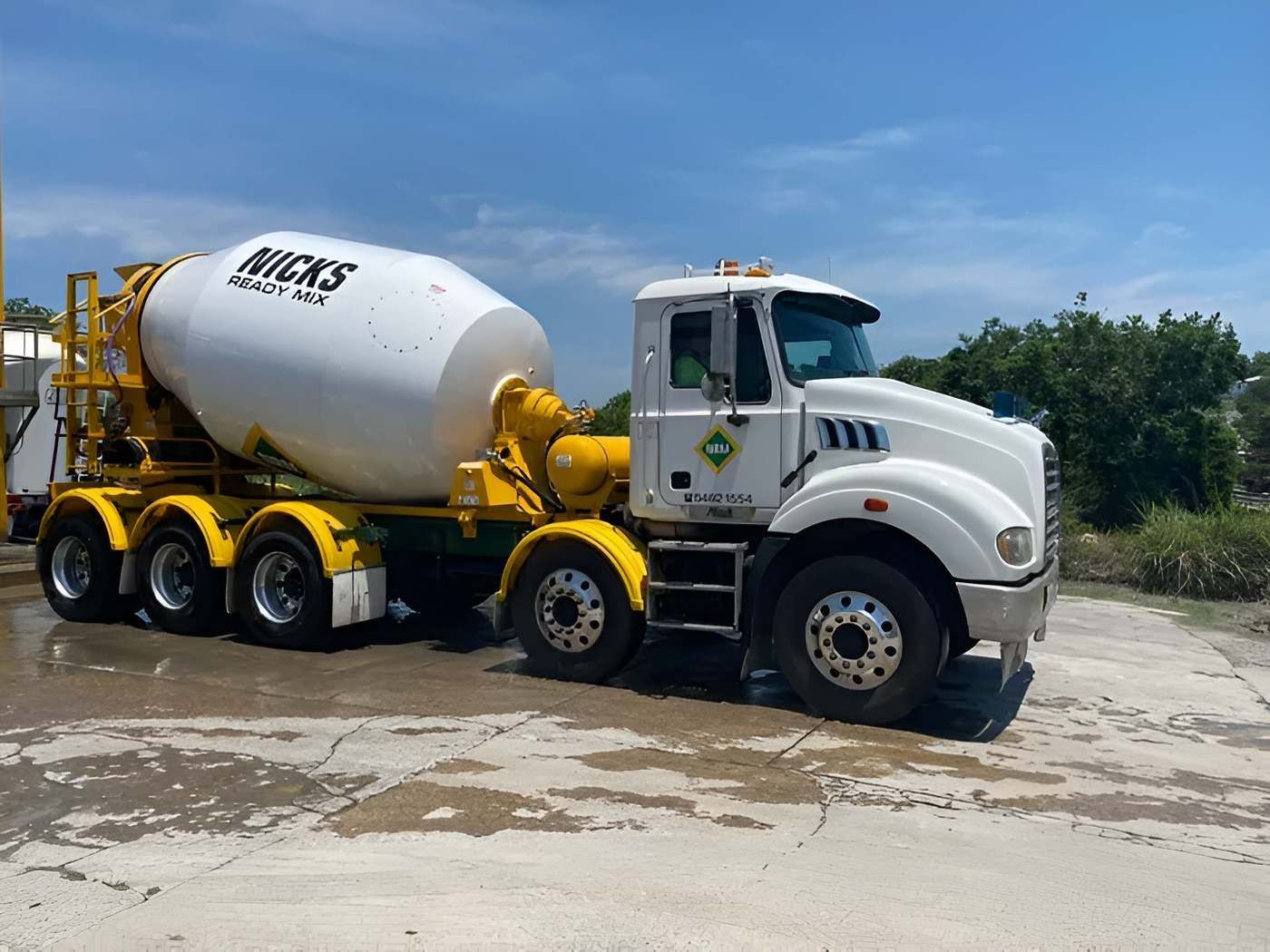 A White and Yellow Concrete Mixer Truck is Parked in a Parking Lot — Nicks Readymix in Monkland, QLD