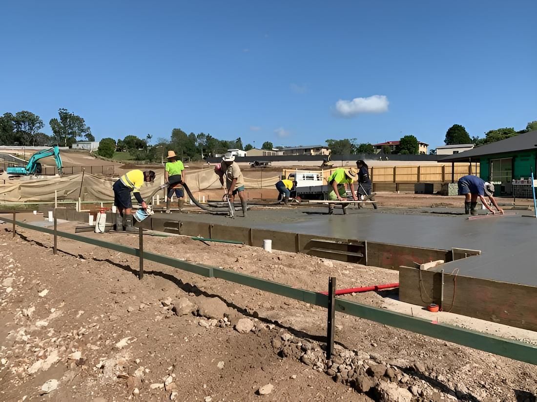 A Concrete Mixer is Pouring Concrete Into a Bucket on a Construction Site — Nicks Readymix in Monkland, QLD
