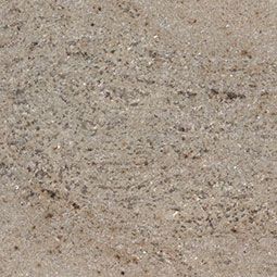 Close-up of beige sand with small pebbles and fine grain texture