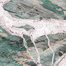 Marbled stone surface with green, white, and gray veining and a faint animal-like figure
