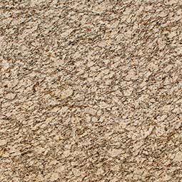 Close-up of beige and tan speckled stone or carpet texture