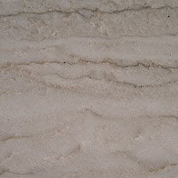 Close-up of beige stone with layered, wavy horizontal texture
