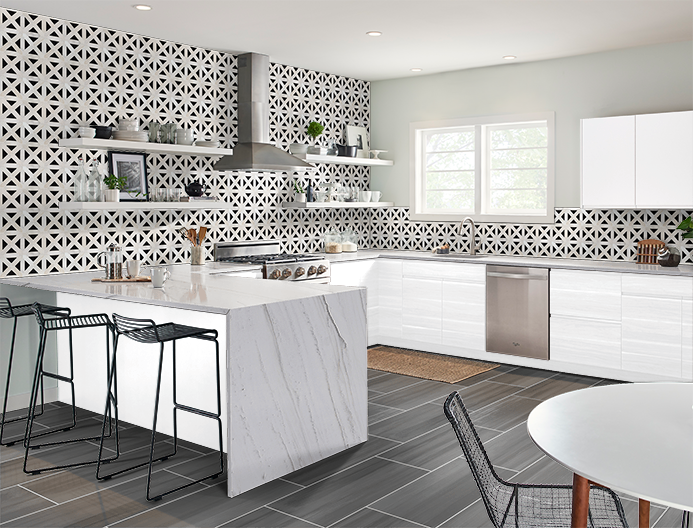 Modern white kitchen with marble island, patterned backsplash, and black bar stools