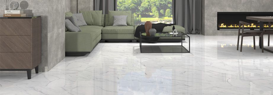 Modern living room with gray sectional, coffee table, fireplace, and large window on polished white floor